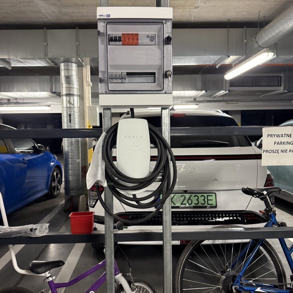 Ładowarka Tesla Wall Connector i dedykowana rozdzielnica na miejscu postojowym w garażu podziemnym w Krakowie